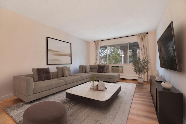 living room featuring a baseboard radiator, a wall mounted air conditioner, and wood finished floors