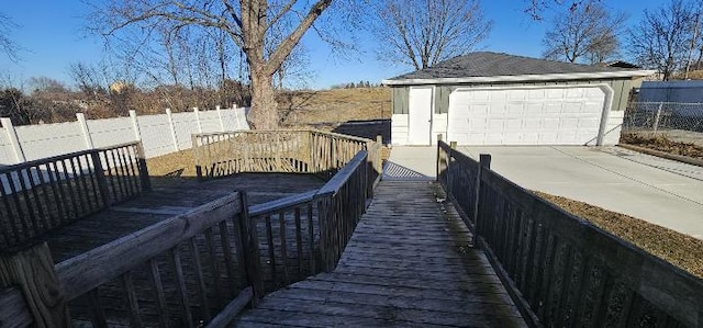 wooden terrace with an outbuilding, fence, and a detached garage