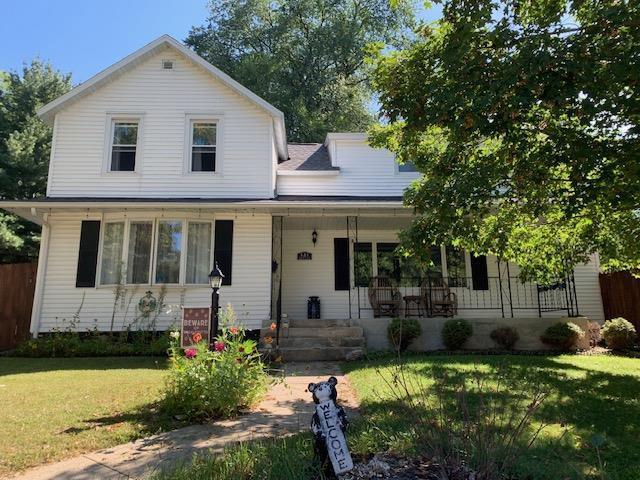 view of front of house featuring covered porch and a front yard