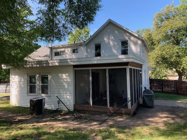 rear view of house featuring central air condition unit, fence, and a sunroom