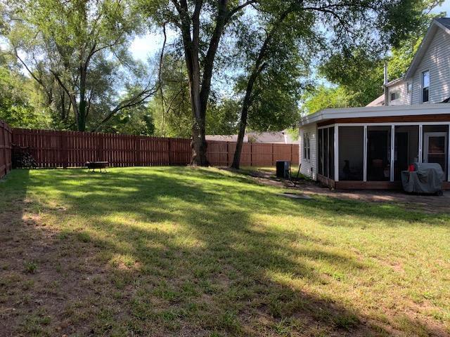 view of yard with a fenced backyard and a sunroom