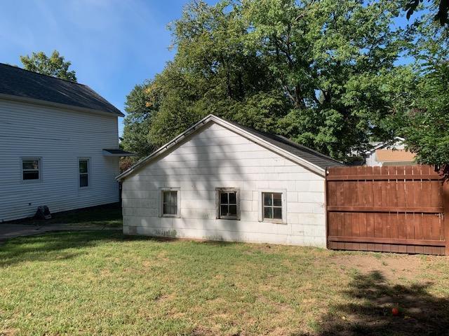 view of home's exterior featuring a lawn and fence