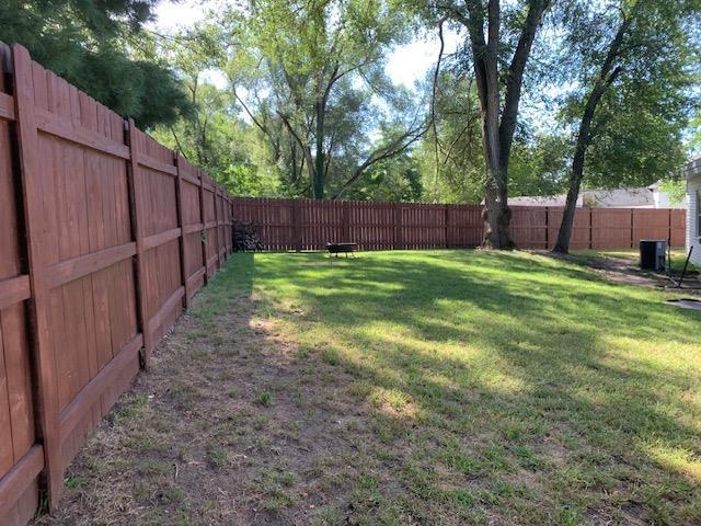 view of yard with central AC and a fenced backyard