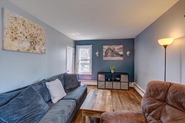 living room with a baseboard radiator, wood finished floors, baseboards, and a baseboard heating unit