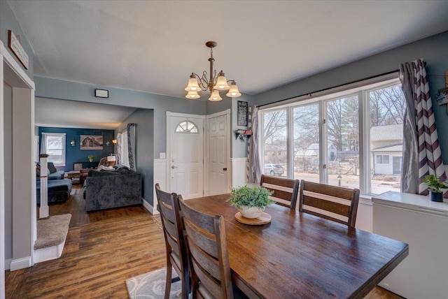 dining room featuring wood finished floors, baseboards, and a chandelier