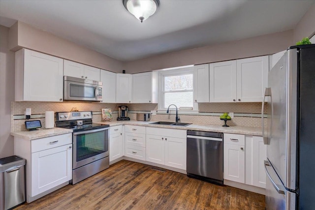 kitchen featuring dark wood-style floors, white cabinetry, stainless steel appliances, and a sink