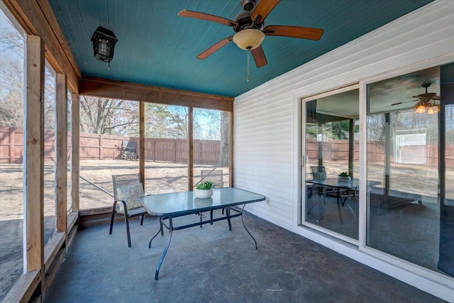 unfurnished sunroom featuring wood ceiling and ceiling fan