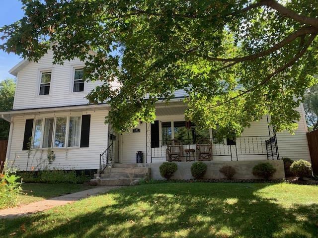 view of front of home with a porch and a front lawn