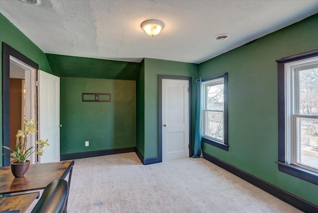 bedroom featuring light carpet, visible vents, multiple windows, and baseboards