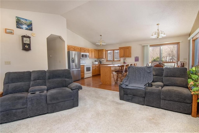 living room featuring lofted ceiling, a notable chandelier, and dark colored carpet