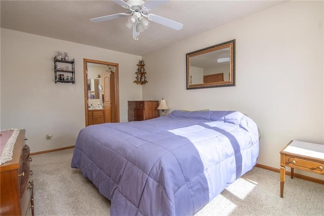 carpeted bedroom with a ceiling fan, a textured ceiling, baseboards, and ensuite bathroom