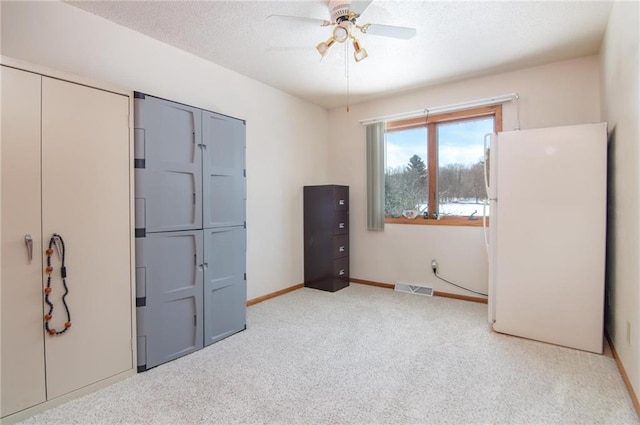 bedroom featuring a textured ceiling, carpet flooring, visible vents, baseboards, and freestanding refrigerator