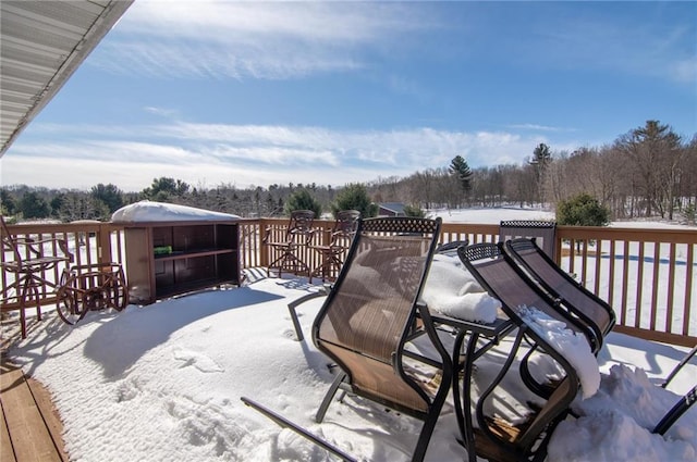 snow covered deck featuring outdoor dining area