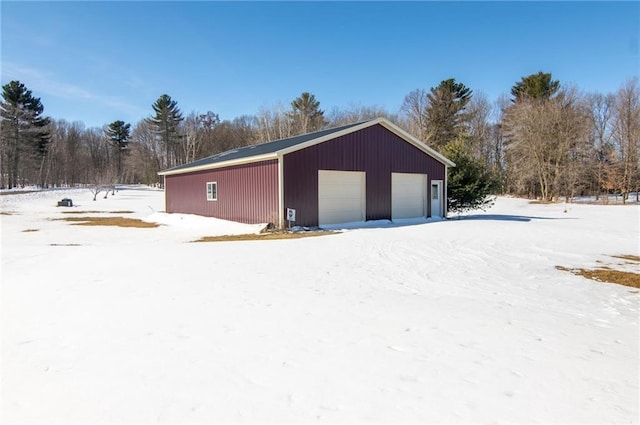 snow covered garage with a garage