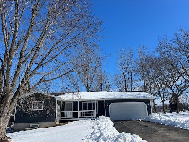 view of front of property featuring aphalt driveway, covered porch, and an attached garage