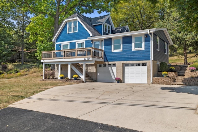 view of front of property featuring a front lawn, concrete driveway, an attached garage, and stairs