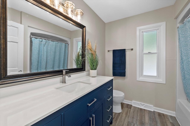 full bath featuring baseboards, visible vents, a shower with curtain, wood finished floors, and vanity