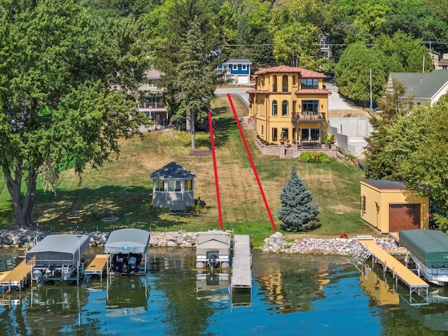 dock area with a water view, a yard, and boat lift