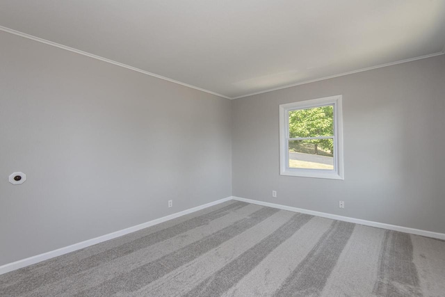 empty room with ornamental molding, carpet flooring, and baseboards