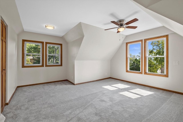 additional living space featuring a ceiling fan, light colored carpet, vaulted ceiling, and baseboards