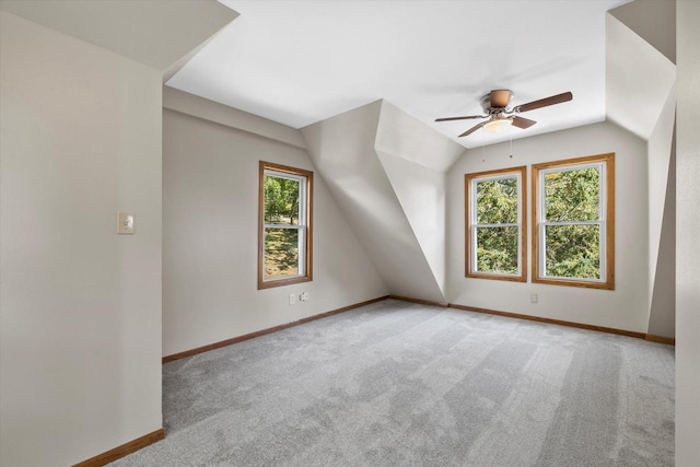 additional living space featuring lofted ceiling, carpet flooring, a ceiling fan, and baseboards