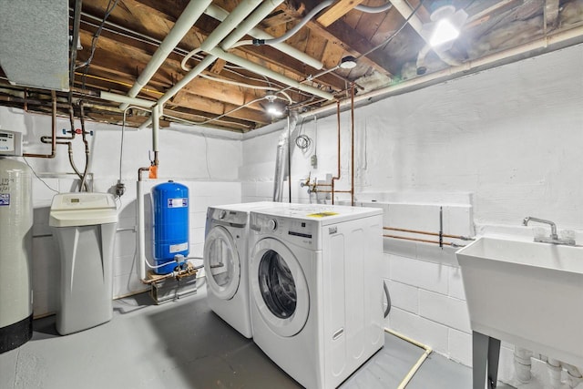 clothes washing area with laundry area, independent washer and dryer, and a sink