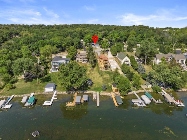 drone / aerial view featuring a water view and a forest view