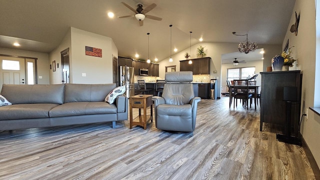 living room with ceiling fan, high vaulted ceiling, and wood finished floors