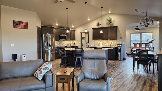 kitchen featuring light countertops, appliances with stainless steel finishes, a ceiling fan, dark brown cabinetry, and wood finished floors