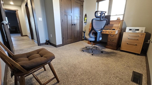 office area with light carpet, baseboards, and visible vents