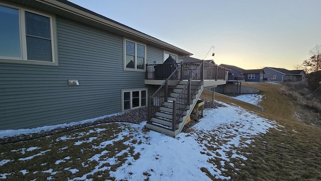 snow covered property featuring stairs and a wooden deck