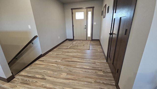 doorway with light wood-type flooring and baseboards