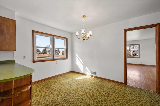 unfurnished dining area with baseboards, visible vents, and a healthy amount of sunlight