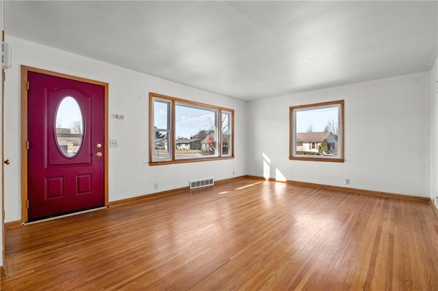 entrance foyer featuring a wealth of natural light, visible vents, light wood-style flooring, and baseboards