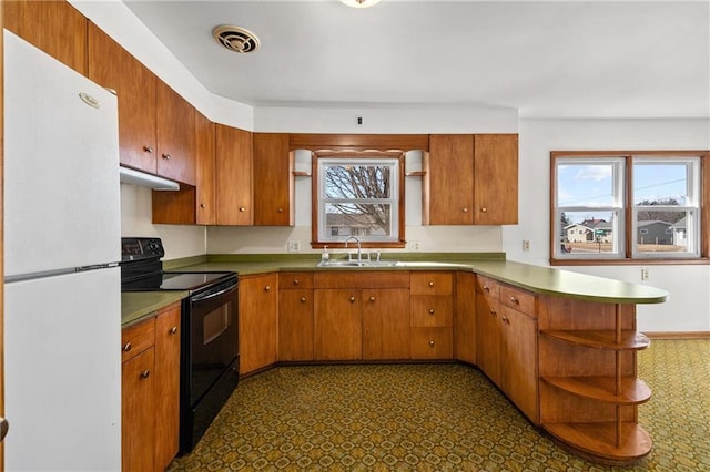 kitchen featuring freestanding refrigerator, a peninsula, black range with electric cooktop, open shelves, and a sink