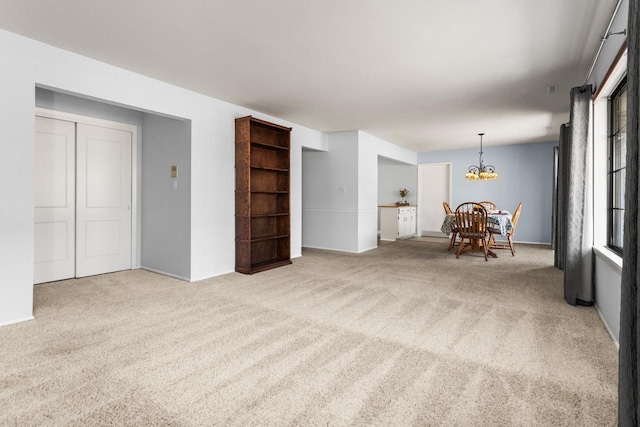 unfurnished living room with a notable chandelier and carpet floors