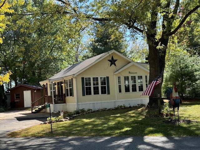 view of front facade with an outbuilding and a front lawn