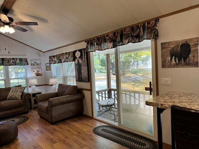 living room featuring vaulted ceiling, ceiling fan, ornamental molding, and wood finished floors