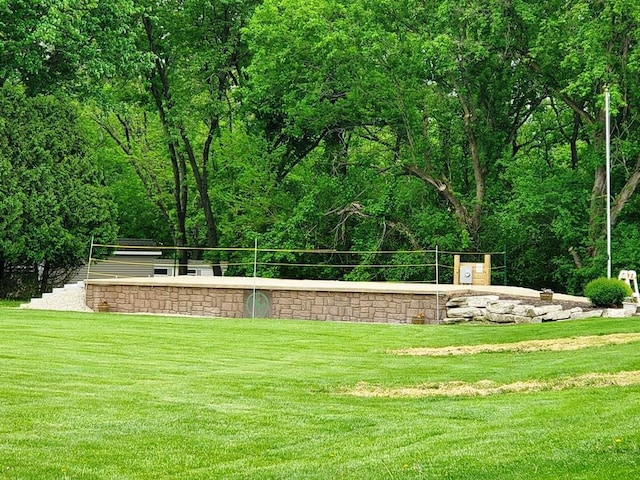 view of home's community featuring a lawn and a wooded view