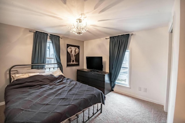 bedroom with carpet floors, baseboards, and a chandelier