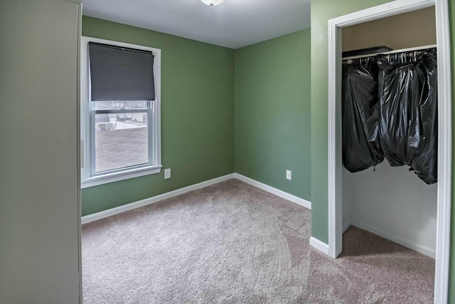 unfurnished bedroom with a closet, carpet, and baseboards