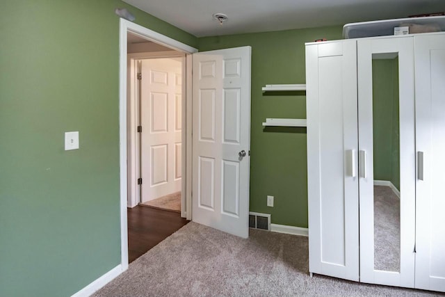 unfurnished bedroom with carpet, visible vents, and baseboards