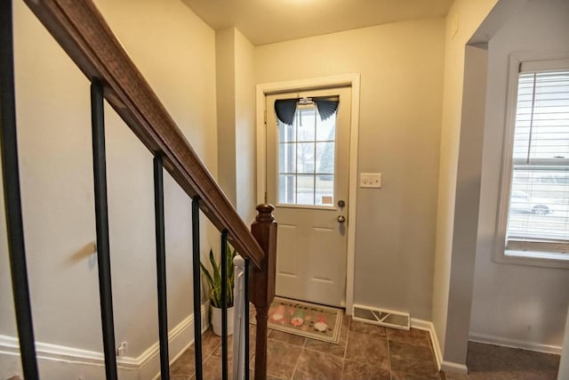 doorway to outside with stairway, plenty of natural light, visible vents, and baseboards