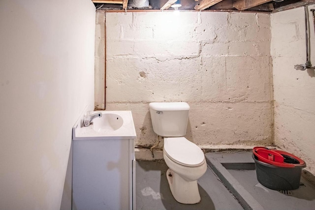 bathroom with unfinished concrete flooring, vanity, and toilet