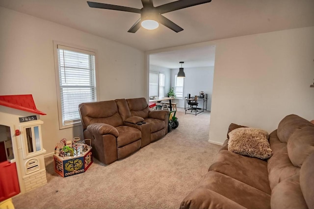 carpeted living area with a ceiling fan