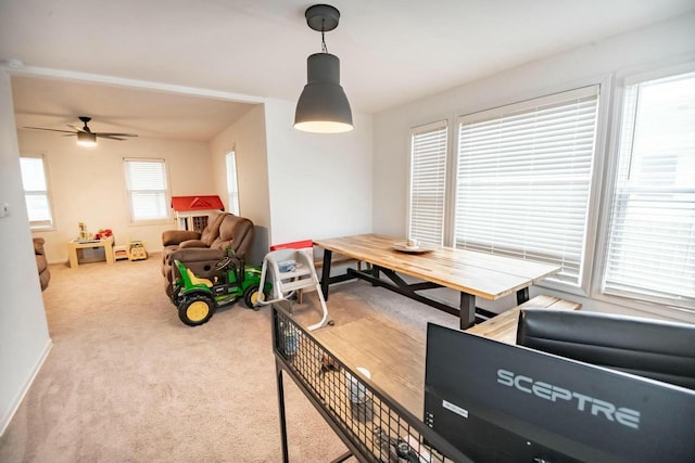 carpeted dining room featuring ceiling fan and baseboards