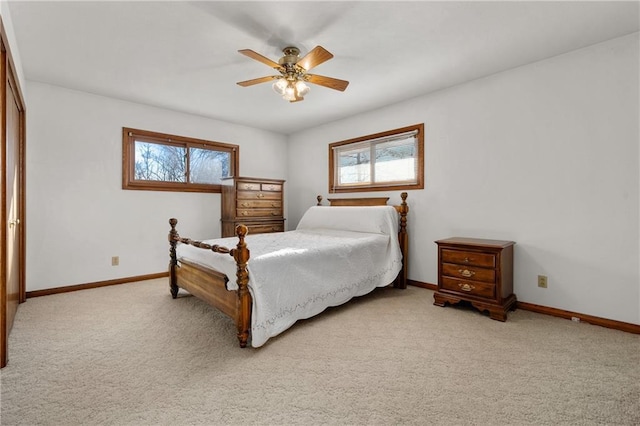 bedroom featuring baseboards, multiple windows, and light colored carpet