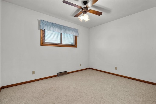 carpeted spare room featuring ceiling fan and baseboards