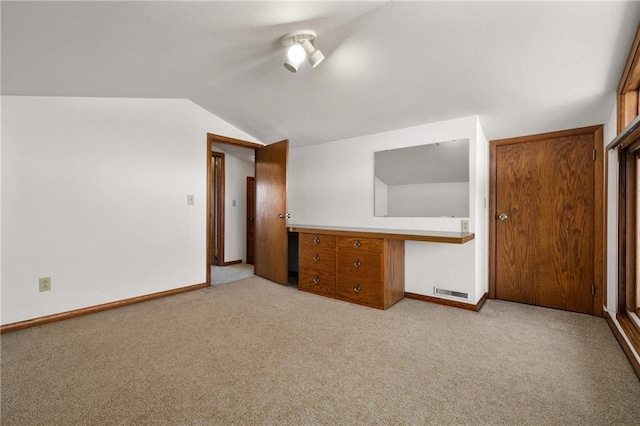 interior space featuring vaulted ceiling, carpet floors, visible vents, and baseboards