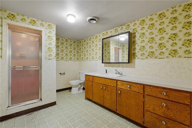 full bath with toilet, wallpapered walls, a shower stall, and vanity